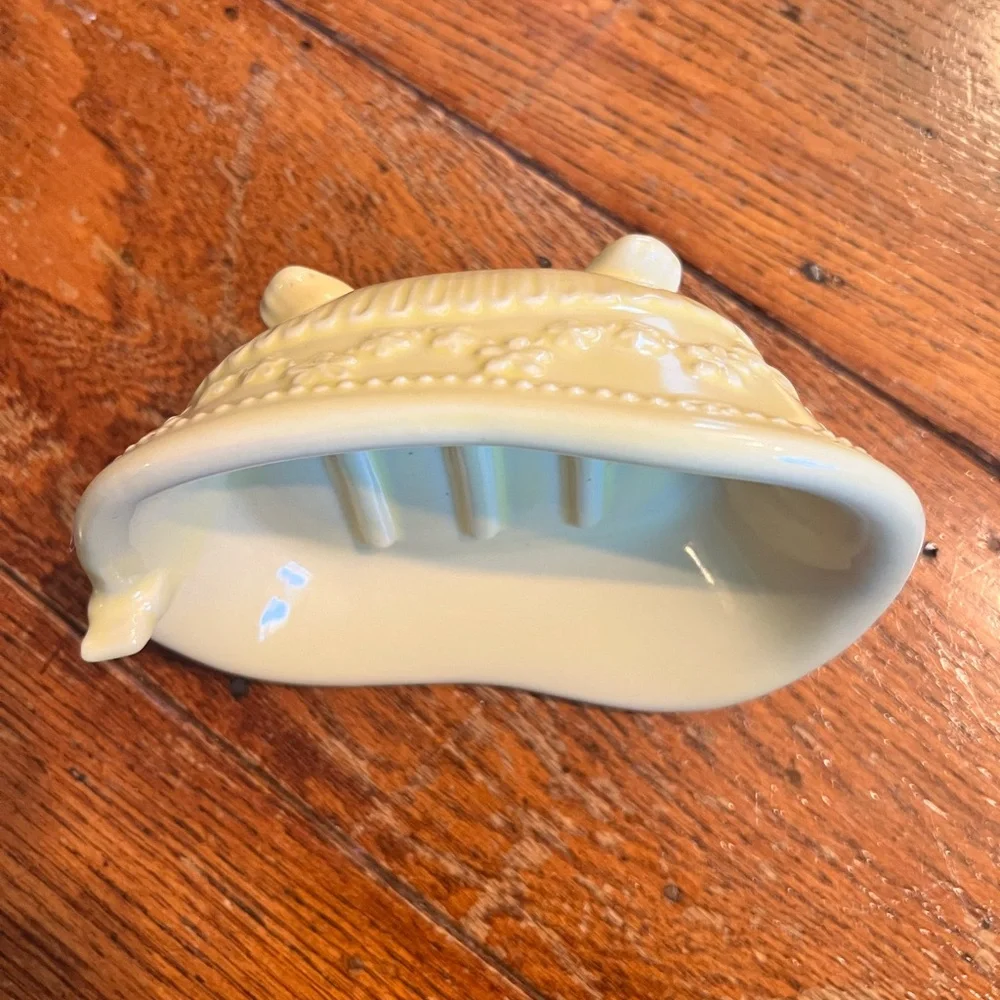 Vintage butter yellow ceramic soap dish shaped like bathtub.